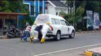 Tenaga Medis PSC Mamuju mendorong mobil ambulance yang mogok ketika akan menjemput pasien Covid-19 (Liputan6.com/Abdul Rajab Umar)