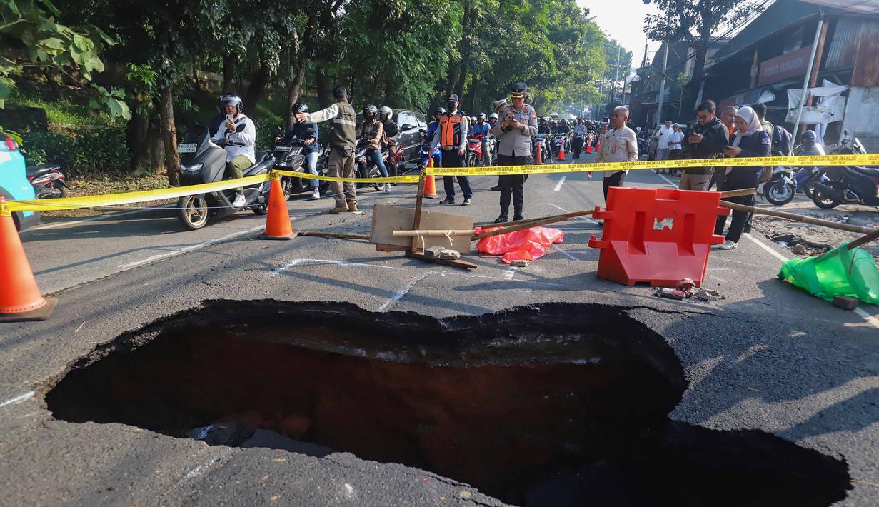 Pengendara melintas di sisi ruas jalan yang ditutup sebagian akibat amblas di Jalan Raya Lenteng Agung, Jakarta Selatan, Jumat (29/5/2026). (merdeka.com/Arie Basuki)