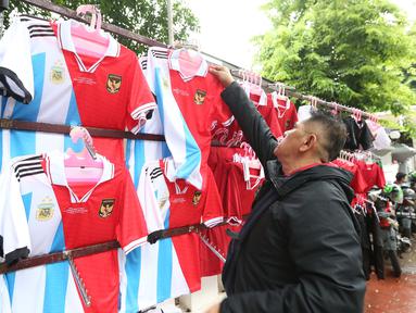 Tak ingin kehilangan momen, beberapa pedagang tampak bertebaran di sekitar area Stadion Utama Gelora Bung Karno  (SUGBK), Senin (19/6/2023) untuk menjajakan dagangannya berupa pernak-pernik pertandingan antara Timnas Indonesia menghadapi Argentina. Pernak-pernik berupa jersey, jaket dan syal dengan harga terjangkau tampak menarik minat beberapa suporter yang melintas. (Bola.com/M Iqbal Ichsan)