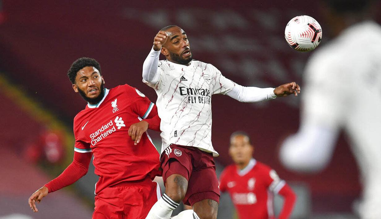 Pemain Liverpool, Joe Gomez, duel udara dengan striker Arsenal, Alexandre Lacazette, pada laga Liga Inggris di Stadion Anfield, Senin (28/9/2020). Liverpool menang dengan skor 3-1. (Paul Ellis/Pool via AP)