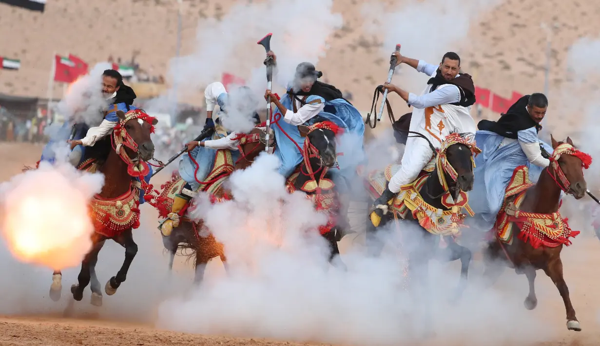 Aksi penunggang kuda saat upacara pembukaan Festival Tan-Tan Moussem Berber ke-14 di Kota Tan-Tan, Maroko, Jumat (6/7). Seluruh suku nomaden di Markoko akan berkumpul di Gurun Sahara. (KARIM SAHIB/AFP)