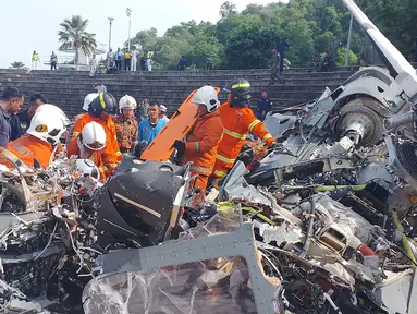 Foto yang dirilis pada tanggal 23 April 2024 oleh Departemen Pemadam Kebakaran dan Penyelamatan Perak ini menunjukkan tim penyelamat memeriksa lokasi kecelakaan setelah dua helikopter militer bertabrakan di Lumut, negara bagian Perak, Malaysia. (Handout/Departemen Pemadam Kebakaran dan Penyelamatan Perak/AFP)