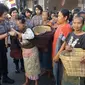 Polwan membagi-bagikan bakul dan kain selendang kepada ibu-ibu buruh gendongan di Solo (Liputan6.com/ Fajar Abrori)