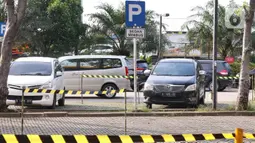 Sejumlah mobil terparkir berjarak di Rest Area KM 13,5 Palm Square Tol Jakarta-Tangerang, Jumat (29/5/2020). Penerepan parkir berjarak dan pengecekan suhu tubuh di area tersebut diberlakukan untuk menekan penyebaran Covid-19. (Liputan6.com/Angga Yuniar)