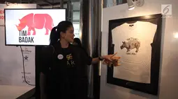 Artis Marcella Zalianty menunjuk karya dalam pameran seni badak Sumatera di Perpustakaan Nasional Indonesia, Jakarta Pusat, Jumat (19/1). Sebanyak 10 seniman muda Indonesia dan Internasional berpartisipasi dalam pameran ini. (Liputan6.com/Arya Manggala)
