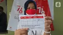 Tenaga kesehatan menunjukkan kartu vaksinasi usai menerima vaksin dosis ketiga atau booster di RSUD Matraman, Jakarta, Jumat (6/8/2021). Pemberian vaksin dosis ketiga atau booster kepada tenaga kesehatan di Indonesia ditargetkan rampung pada pekan kedua Agustus 2021 (Liputan6.com/Herman Zakharia)