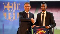 Presiden Barcelona, Josep Maria Bartomeu, foto bersama dengan bek barunya, Nelson Semedo, di Stadion Camp Nou, Katalonia, Jumat (14/7/2017). Pemain 23 tahun itu didatangkan dari Benfica dengan harga 26,2 juta poundsterling. (AFP/Lluis Gene)
