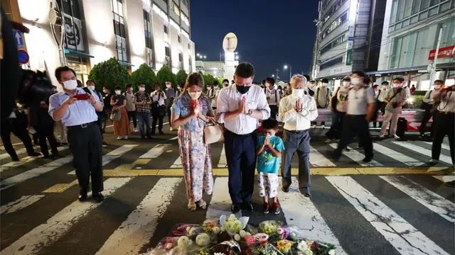Orang-orang berdoa di lokasi mantan Perdana Menteri Jepang Shinzo Abe ditembak saat pidato di Nara, Jumat, 8 Juli 2022. (Kyodo News via AP)