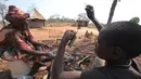 Warga setempat mengolah daging tikus yang akan dibuat menjadi makanan di Chidza, Zimbabwe (23/9). Selain dikonsumsi untuk mereka sendiri, warga menjual daging tikus ini ke pengendara dari negara tetangga yang melintas. (AP Photo/Tsvangirayi Mukwazhi)