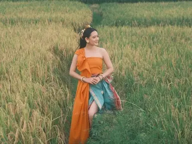 Tampil dalam balutan baju tradisional berwarna jingga membuat Laura nampak semakin menawan. Dalam penampilannya tersebut, ia juga mengenakan aksesoris kepala sebagai pelengkap. (Liputan6.com/IG/laura_theux)