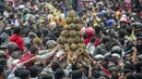 Ribuan pengunjung berebut gunungan durian saat festival Kenduren di Jombang, Jawa Timur, Minggu (3/3). Festival tersebut merupakan acara tahunan yang digelar setiap memasuki musim panen durian sebagai bentuk syukur petani kepada Tuhan (Juni Kriswanto/AFP)