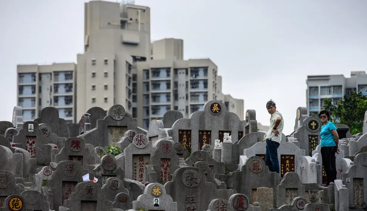 Warga mengunjungi makam kerabat saat Festival Chung Yeung atau Tomb Sweeping Day di sebuah pemakaman di Hong Kong, 17 Oktober 2018. Pada saat perayaan, warga keturunan China mengunjungi dan membersihkan makam-makam leluhur mereka.  (Anthony WALLACE/AFP)