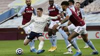 Pemain Manchester City, Phil Foden, melepaskan tendangan saat melawan Aston Villa pada laga Liga Inggris di Stadion Villa Park, Rabu (21/4/2021). City menang dengan skor 2-1. (Carl Recine/Pool via AP)