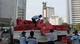 Petugas Dishub menurunkan pembatas jalan di kawasan Bundaran HI, Jakarta, (31/12). Hal ini dilakukan agar  perayaan tahun baru tidak dipusatkan di Bundaran Hotel Indonesia (HI) atau penyelenggaraan car free night.(Liputan6.com/Angga Yuniar)