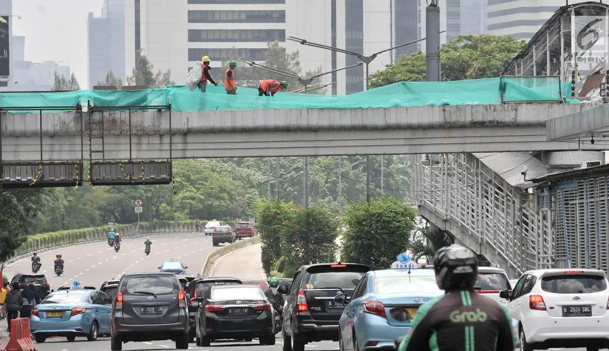 Suasana lalu lintas saat pekerja membongkar jembatan penyeberangan orang (JPO) Tosari, Jakarta, Minggu (16/12). Pembongkaran JPO Tosari ditergetkan selesai pada 20 Desember 2018. (Merdeka.com/Iqbal Nugroho)