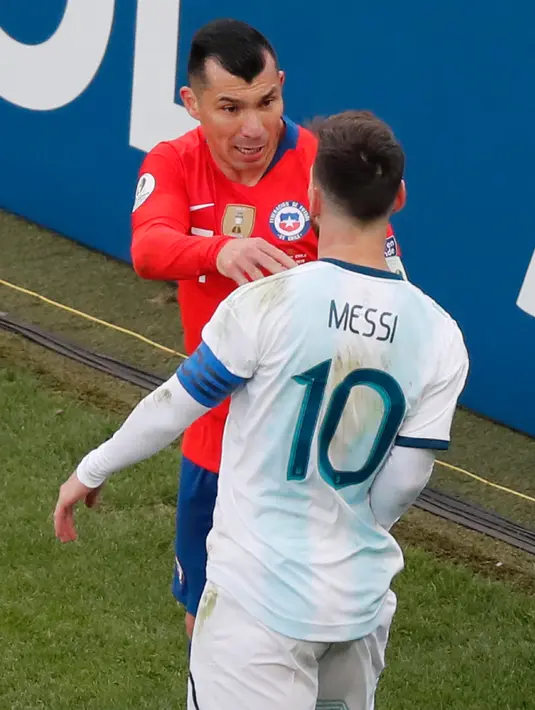 Penyerang Argentina, Lionel Messi berseteru dengan gelandang Chile, Gary Medel selama perebutan posisi ketiga Copa America 2019 di Arena Corinthians, Brasil (6/7/2019). Insiden tersebut berawal dari Messi yang mendorong Medel dari belakang di lini pertahanan Chile. (AP Photo/Nelson Antoine)