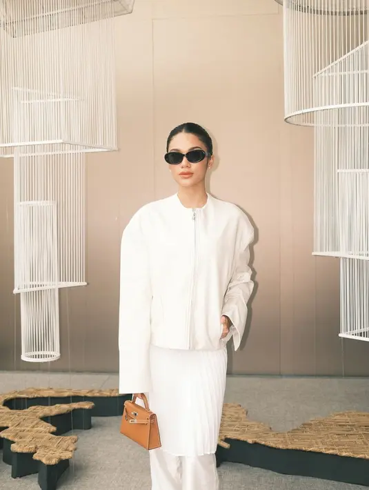 Sementara itu, Azizah Salsha tampil serba putih mengenakan jaket zipper panjang yang dipadukan dengan celana panjang dan pleats mini skirt.  [IG/@aaliyah.massaid/@azizahsalsha].