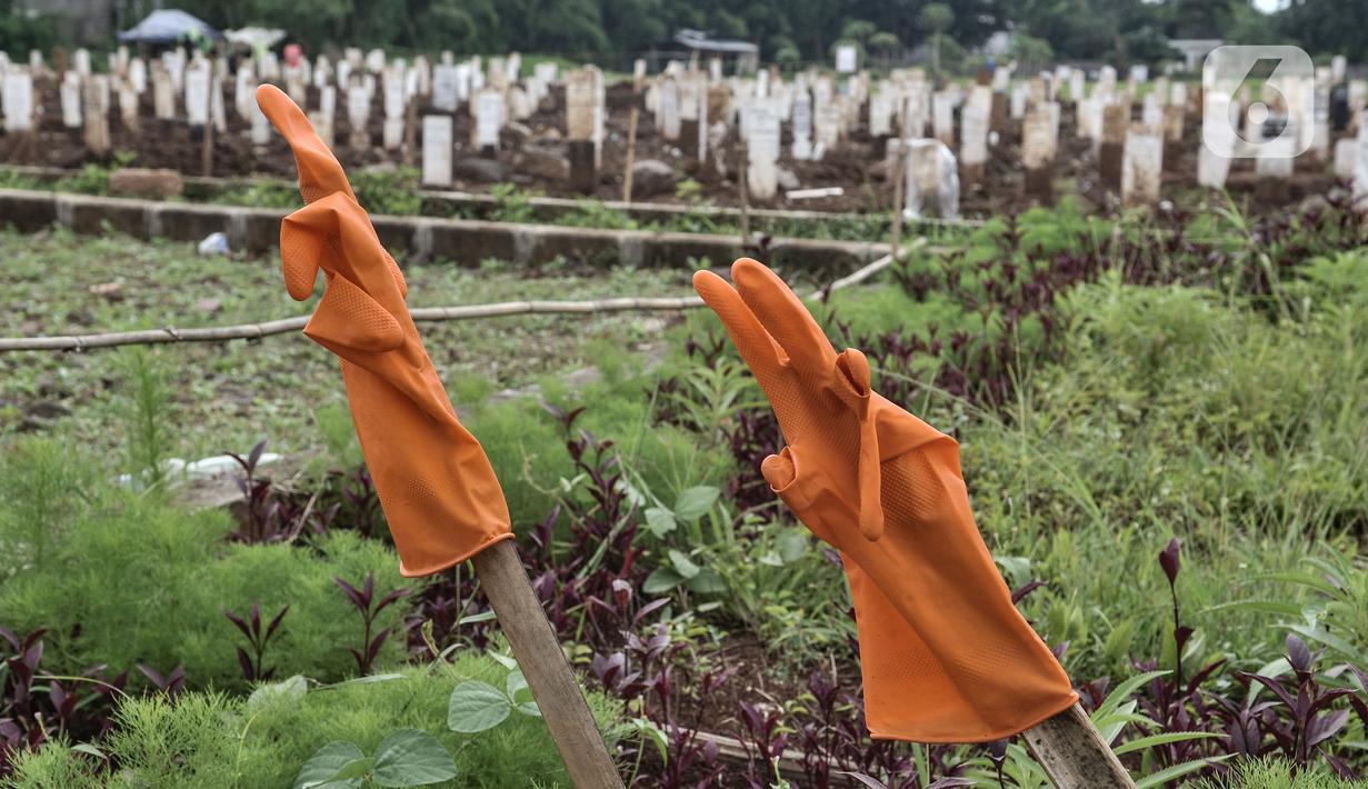 Sarung tangan milik petugas saat dijemur di dekat kompleks makam protokol Covid-19 di TPU Bambu Apus, Jakarta, Selasa (2/3/2021). TPU Bambu Apus kini tidak lagi menampung pemakaman jenazah protokol Covid-19 akibat lahan di dua blok sudah penuh dan dialihkan ke TPU Srengseng Sawah. (merdeka.com/Iqbal
