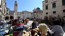 Wisatawan duduk di teras Stradun, jalan utama kota tua Dubrovnik pada 28 Maret 2019. Tahun lalu lebih dari 1,2 juta turis mengunjungi Dubrovnik, kota yang paling banyak dikunjungi di Kroasia. (Denis LOVROVIC / AFP)