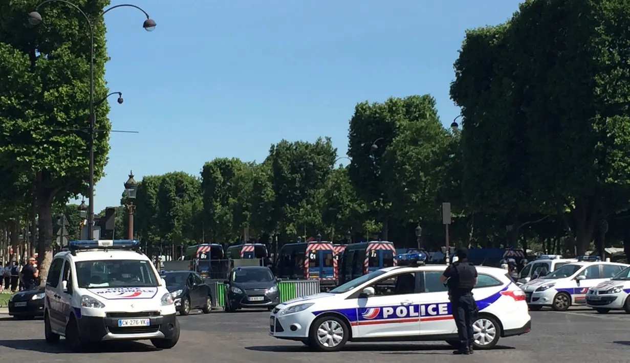 Kendaraan polisi Prancis menutup akses jalan Champs Elysees di Paris, Prancis, Senin (19/6). Sebuah mobil mengeluarkan api usai sengaja menabrak kendaraan polisi di lokasi wisata terkenal tersebut yang menewaskan pengemudinya (AP Photo/Matthieu Alexandre)