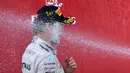 Pebalap Mercedes, Nico Rosberg, terkena semprotan sampanye saat merayakan gelar juara F1 GP Baku di podium Sirkuit Baku, Azerbaijan, Minggu (19/6/2016). (AFP/Kirill Kudryavtsev)