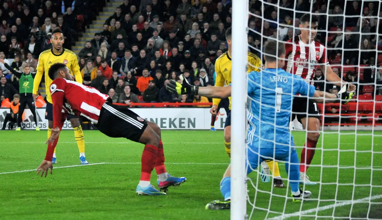 Striker Sheffield United Lys Mousset (kiri) mencetak gol ke gawang Arsenal yang dijaga kiper Jerman Bernd Leno pada pertandingan Liga Inggris di Bramall Lane, Sheffield, Inggris, Senin (21/10/2019). Sheffield United menang1-0. (AP Photo/Rui Vieira)