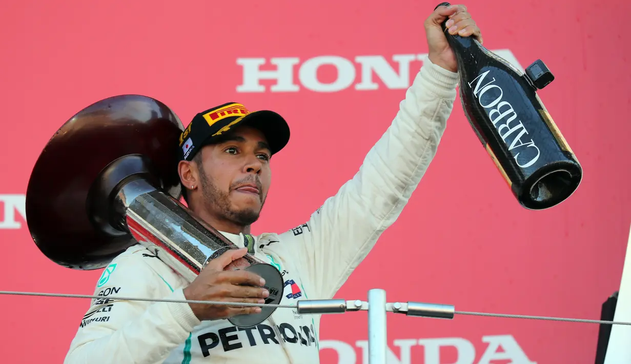 Pembalap Mercedes, Lewis Hamilton mengangkat trofi setelah memenangi Formula Satu (F1) Grand Pix Jepang di Sirkuit Suzuka, Jepang (7/10). Dengan kemenangan ini, Hamilton unggul 67 poin atas pesaing terdekatnya, Sebastian Vettel. (AP Photo/Ng Han Guan)
