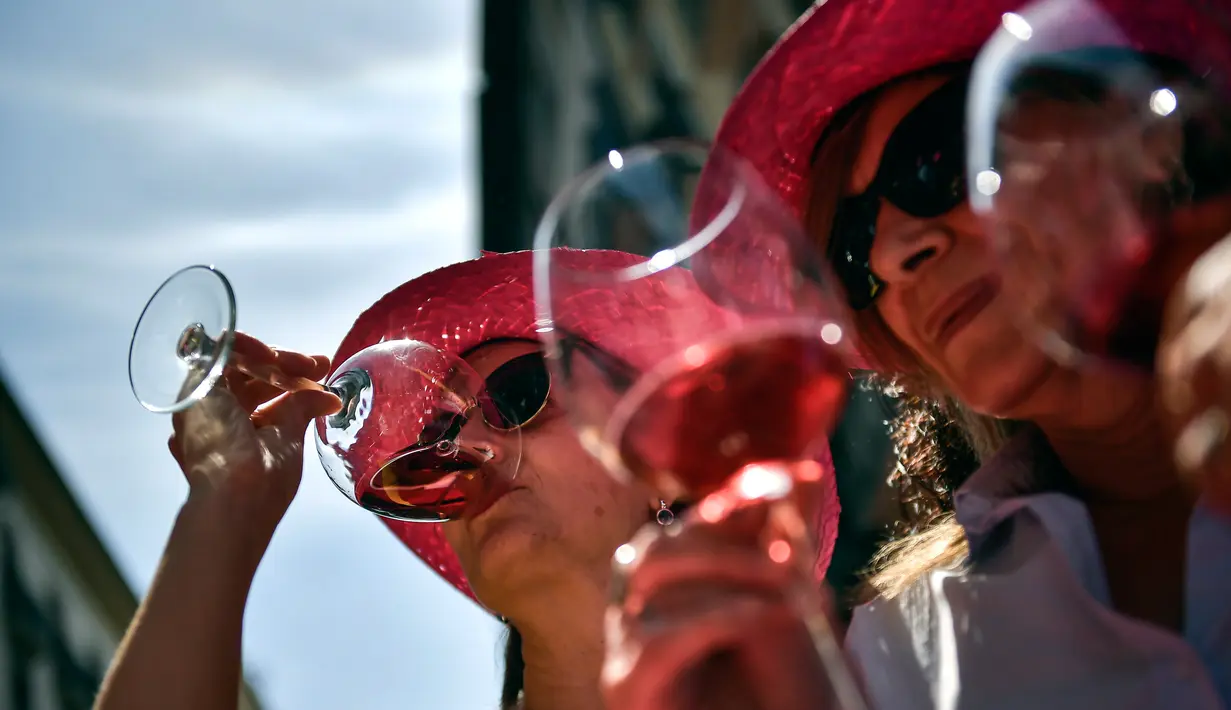 Para wanita mencicipi anggur mawar Spanyol untuk mempromosikan minuman tersebut di Pamplona, Spanyol, Sabtu (19/5). (AP Photo/Alvaro Barrientos)