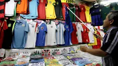 Seorang pedagang kaos tim peserta Piala Dunia 2014 menjajakan dagangannya di Pasar Baru, Jakarta, Rabu (11/6/14). (Liputan6.com/Faizal Fanani)