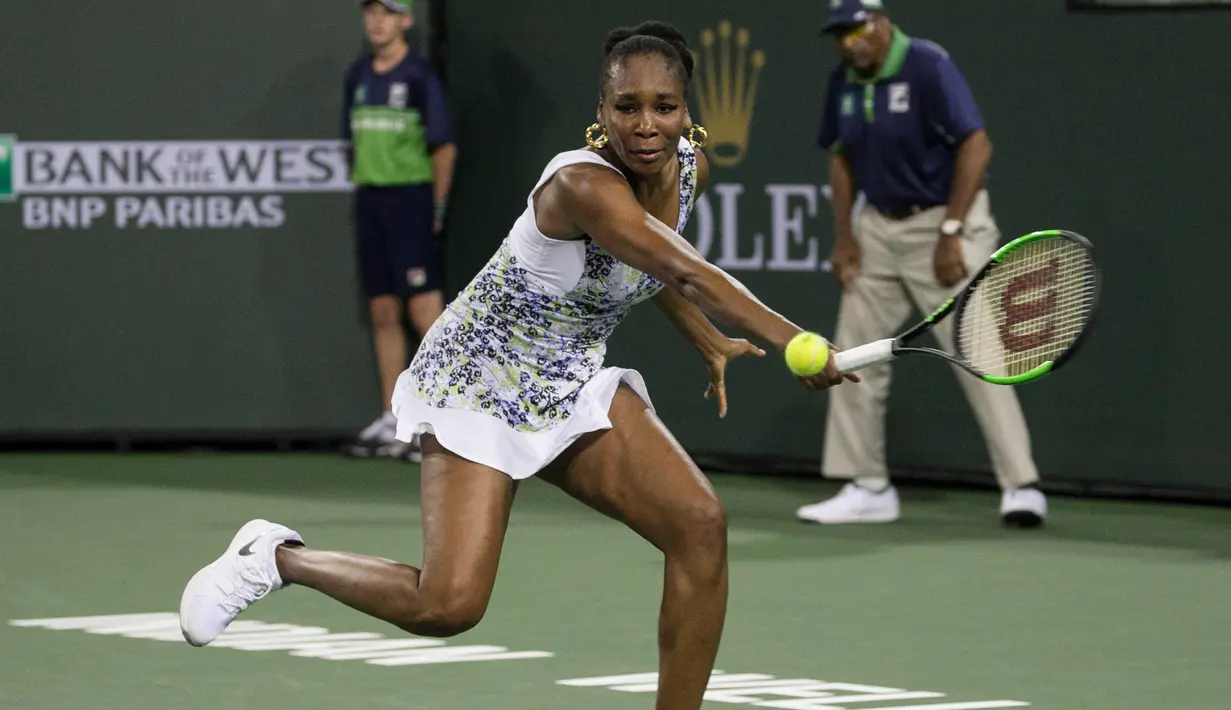 Venus Williams memukul bola saat melawan adiknya Serena Williams saat putaran ketiga turnamen tenis BNP Paribas Open Open di Indian Wells Tennis Garden, California (12/3). Venus Williams menang 6-3, 6-4 atas adiknya. (AP Photo/Crystal Chatham)