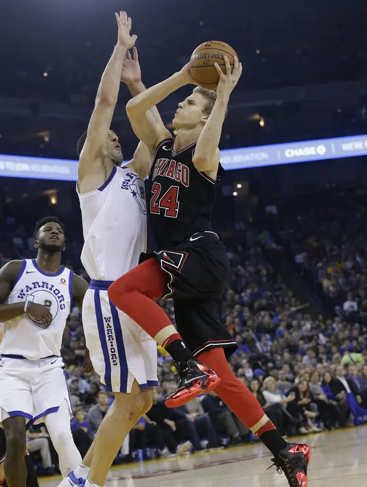 Pemain Chicago Bulls, Lauri Markkanen (kanan) melakukan tembakan melewati adangan pemain  Warriors, Zaza Pachulia pada laga NBA basketball game di Oracle Arena, Oakland, (24/11/2017). Warriors menang 143-94. (AP/Jeff Chiu)