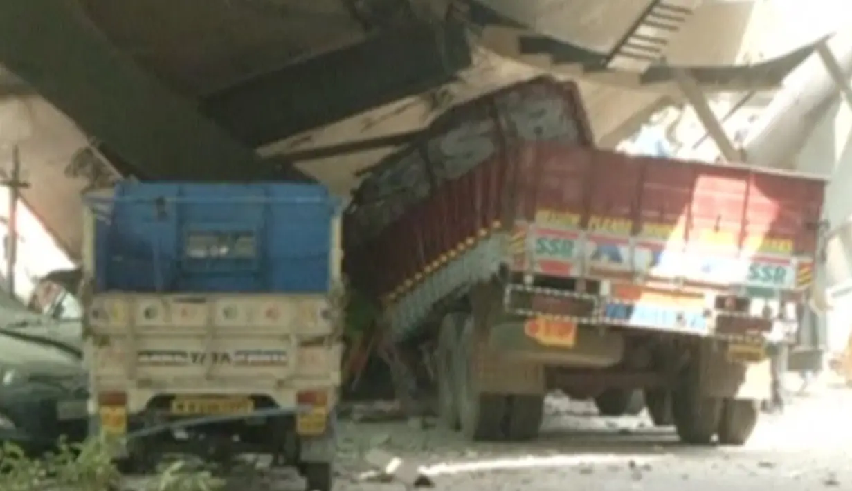 Kendaraan terlihat terjebak di runtuhan sebuah jembatan layang yang ambruk di Kolkata, India, Kamis (31/3). Setidaknya 10 orang tewas dan sekitar 150 orang lainnya tertimpa reruntuhan. (REUTERS/ANI via Reuters)