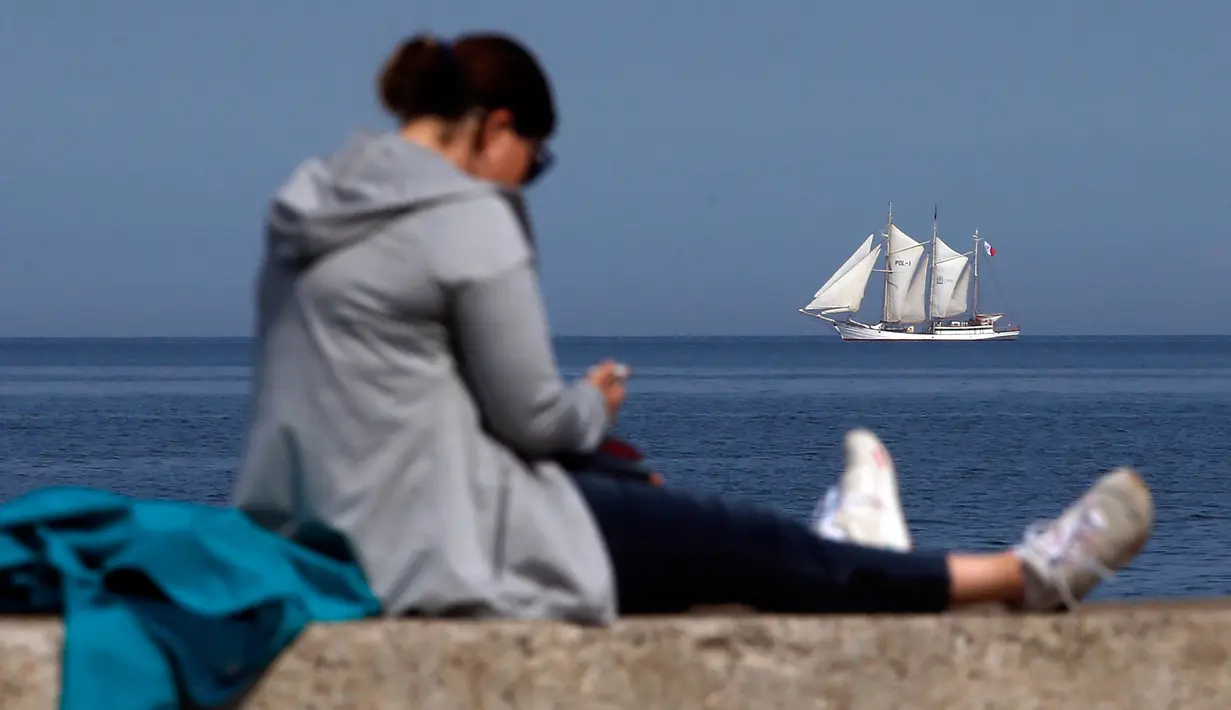 Seorang wanita beristirahat saat sebuah kapal berlayar di sepanjang pantai Laut Baltik dekat Gdynia, Polandia utara (24/5/2019). Perairan Laut Baltik mengalir ke Kattegat dan Laut Utara melewati Öresund, Sabuk Besar dan Sabuk Kecil. (AP Photo/Darko Vojinovic)