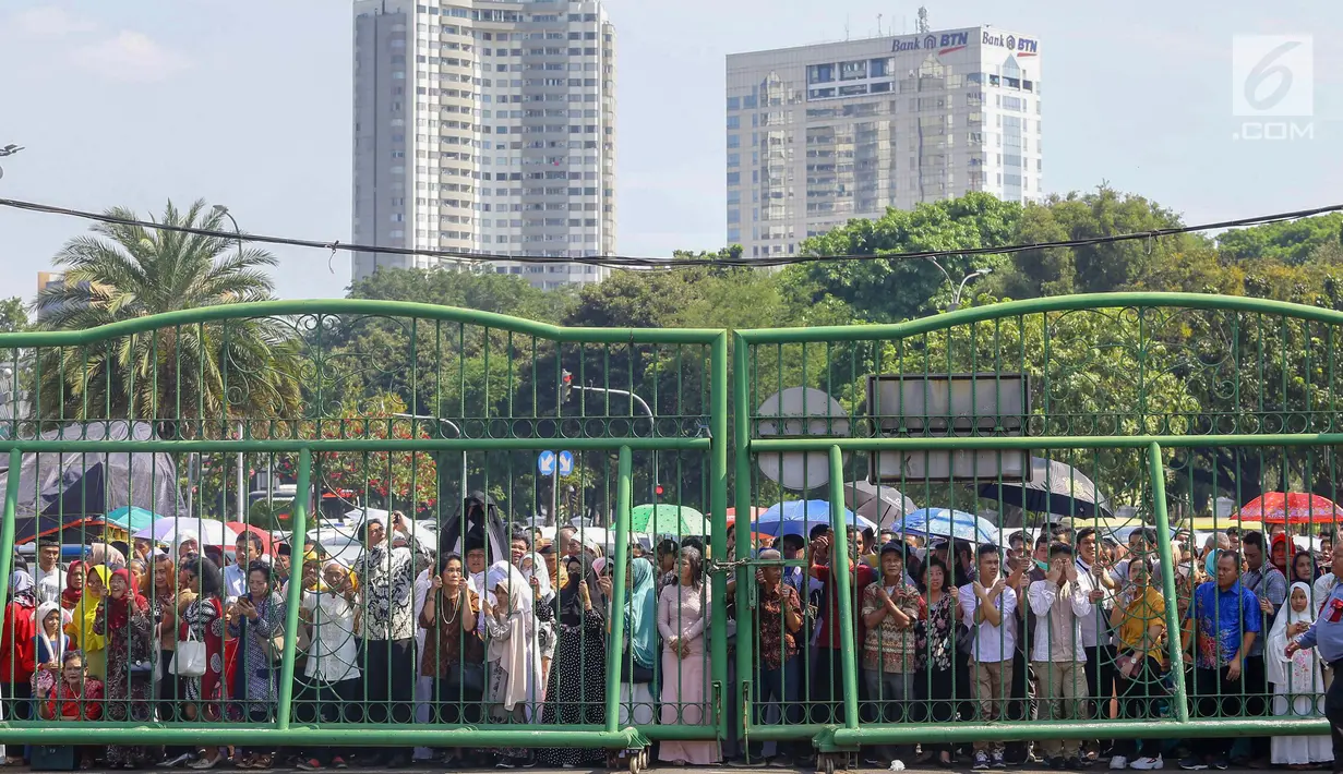 Warga mengantre di kawasan Silang Monas, untuk mengikuti Open House Jokowi di Istana Kepresidenan, Jakarta Rabu (5/6/2019). Warga mulai rela antre setelah Salat Id meski Istana baru dibuka pada pukul 10.00 WIB. (Liputan6.com/HO/Grandy)