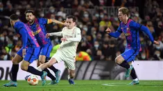 Penyerang Galatasaray, Kerem Aktürkoglu berusaha melewati tiga pemain Barcelona pada pertandingan leg pertama babak 16 besar Liga Europa di stadion Camp Nou di Barcelona (11/3/2022). Barcelona bermain imbang atas Galatasaray 0-0. (AFP/Lluis Gene)