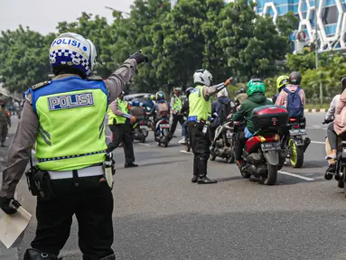 Petugas kepolisian lalu lintas memberhentikan pengendara motor saat Operasi Zebra Jaya 2020 di kawasan Cawang, Jakarta, Senin (26/10/2020). Operasi Zebra Jaya dilaksanakan pada 26 Oktober-8 November 2020 untuk menekan jumlah pelanggaran lalu lintas. (Liputan6.com/Faizal Fanani)