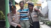 Polisi menggendong pemilih disabilitas ke TPS. (Liputan6.com/Ola Keda)