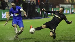 Pemain West Ham United, Mark Noble, berusaha menghalau tendangan pemain Stockport County, Liam Hogan,  pada laga Piala FA di Stadion Edgeley Park, Senin (11/1/2021). West Ham United menang dengan skor tipis 1-0. (Martin Rickett/Pool via AP)