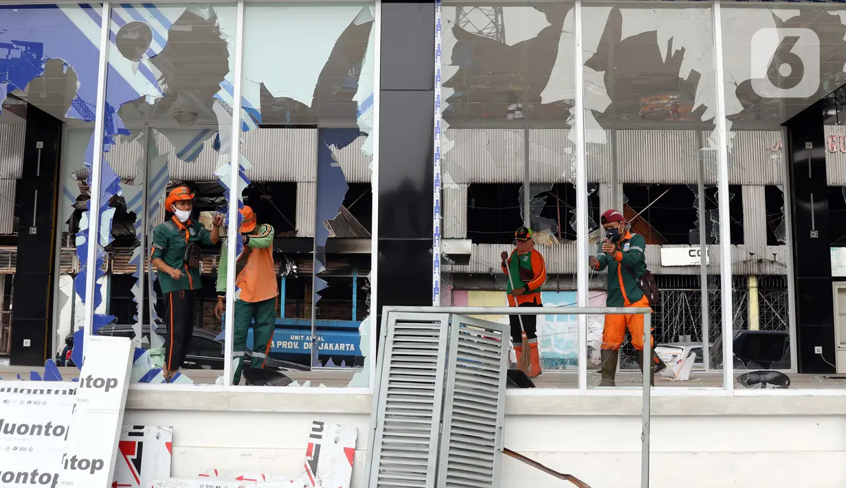 Petugas PPSU membersihkan sisa pecahan kaca di halte transjakarta Senen, Jakarta, Jumat (9/10/2020). Unjuk rasa menentang disahkannya Omnibus Law UU Cipta Kerja berujung aksi anarkis merusak berbagai fasilitas umum pada Kamis malam (8/10). (Liputan6.com/Helmi Fithriansyah)