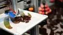 Sebuah mesin pencetak 3 dimensi sedang bekerja membuat coklat dalam acara Brussels Chocolate Fair di Brussels, Belgia (10/2). (AFP/Emmanuel Dunand)