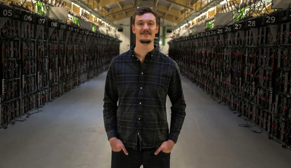 Kepala Operasi, Philip Salter berpose diantara rig pertambangan di pabrik bitcoin 'Genesis Farming' di dekat Reykjavik, Islandia (16/3). (AFP Photo/Halldor Kolbeins)