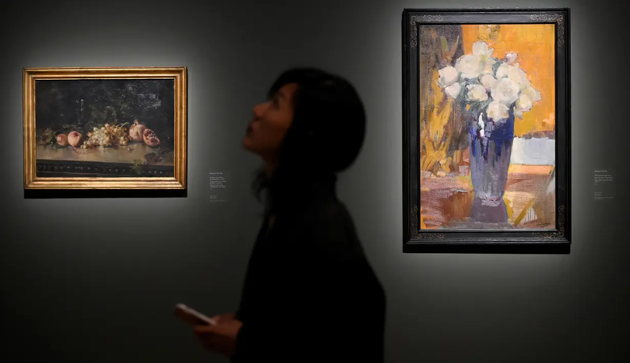 Pengunjung berdiri di samping lukisan Mawar Putih dari Taman Rumah (kanan) (1945) karya pelukis Spanyol Joaquin Sorolla (1863-1923) saat pameran di Brussels, Belgia, Jumat (22/2). Pameran dibuka pada23 Februari sampai 27 Mei 2018 (AFP PHOTO/JOHN THYS)