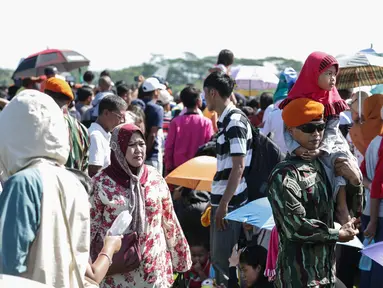 Masyarakat menyaksikan atraksi dalam Hut TNI-AU ke-71 di Taxi Way Skuadron Udara Bandara Halim Perdanakusuma, Jakarta, Minggu (9/4). Dalam rangka memperingati HUT ke-71, TNI AU memamerkan atraksi ratusan pesawat. (Liputan6.com/Faizal Fanani)