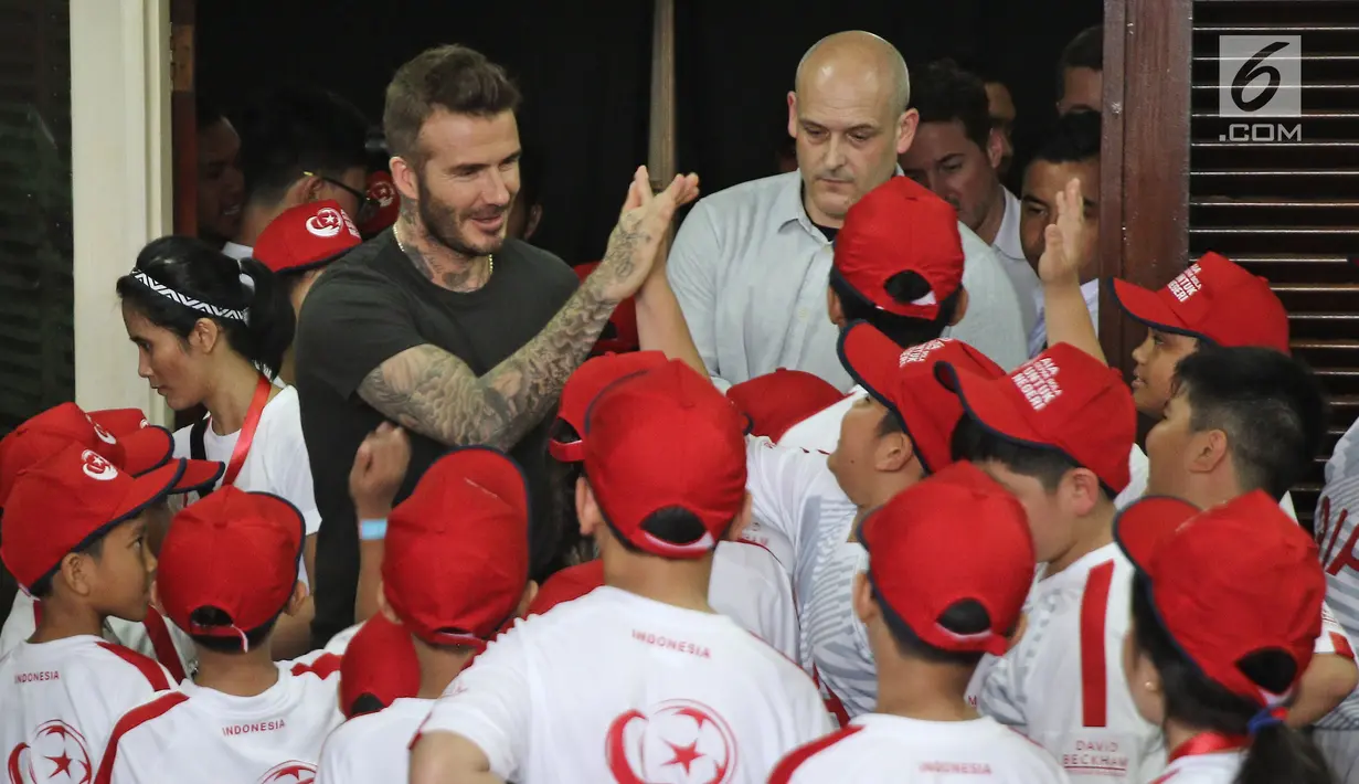 Mantan bintang sepak bola Inggris David Beckham menyapa anak-anak pada acara AIA Sepak Bola untuk Negeri di Jakarta, Minggu (25/3). David tampil di Stadion Soemantri Brodjonegoro dengan membagikan 10 ribu bola. (Liputan6.com/Herman Zakharia)