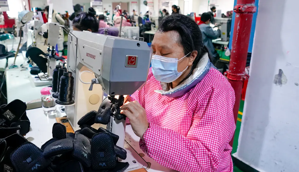 Aktivitas pekerja di sebuah pabrik sepatu di wilayah Xiushan, Chongqing, China barat daya, Jumat (27/2/2020). Kegiatan produksi dan kehidupan sehari-hari warga berangsur normal berkat upaya pengendalian virus corona COVID-19 yang efektif di Xiushan. (Xinhua/Liu Chan)