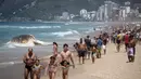 Pengunjung berjalan melewati bangkai paus bungkuk di tepi pantai Ipanema, Rio de Janeiro, Brasil, Rabu (15/11). Peneliti belum memastikan penyebab kematian paus sepanjang 12 meter tersebut. (AFP PHOTO / Leo Correa)