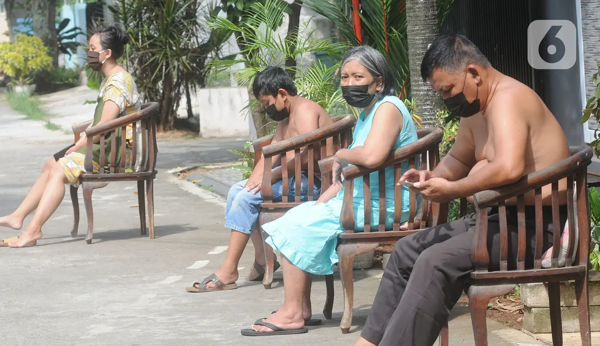 Warga berjemur untuk meningkatkan imunitas tubuh di pinggir jalan kompleks Perumahan Vila Cinere Mas, Depok, Kamis (8/7/2021). Saat ini lebih dari 50 warga Vila Cinere Mas terpapar Covid-19 dan menjalani isolasi mandiri di rumah masing-masing. (merdeka.com/Arie Basuki)