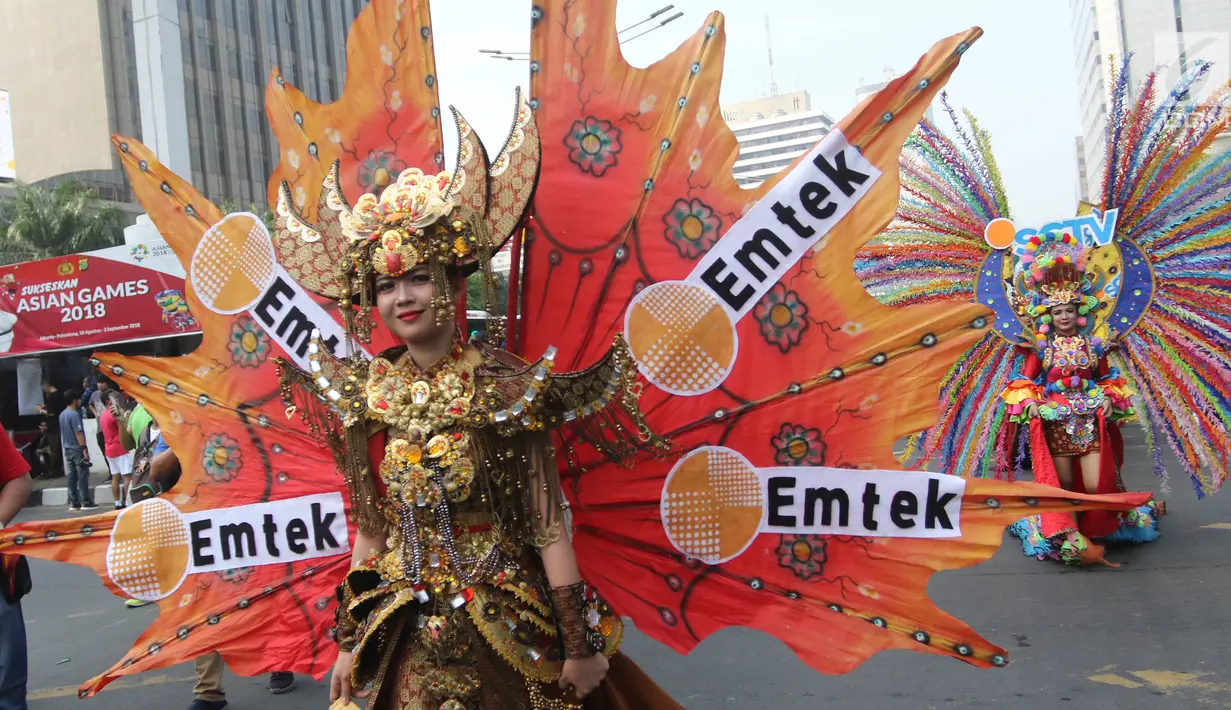 Peserta berkostum Emtek memeriahkan parade Asian Games 2018 di Jalan Thamrin, Jakarta, Minggu (13/5). Tak hanya dari komunitas, peserta parade ini juga datang dari karyawan PT Elang Mahkota Teknologi (Emtek). (Liputan6.com/Arya Manggala)