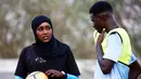 Salma al-Majidi berbincang dengan pemain klub Al-Ahly Al-Gadaref selama latihan di kota Gedaref, timur Khartoum (17/2). Salma tahu cara untuk mengambil bagian dalam olahraga yang dicintainya adalah melatih tim sepak bola pria. (AFP Photo/Ashraf Shazly)