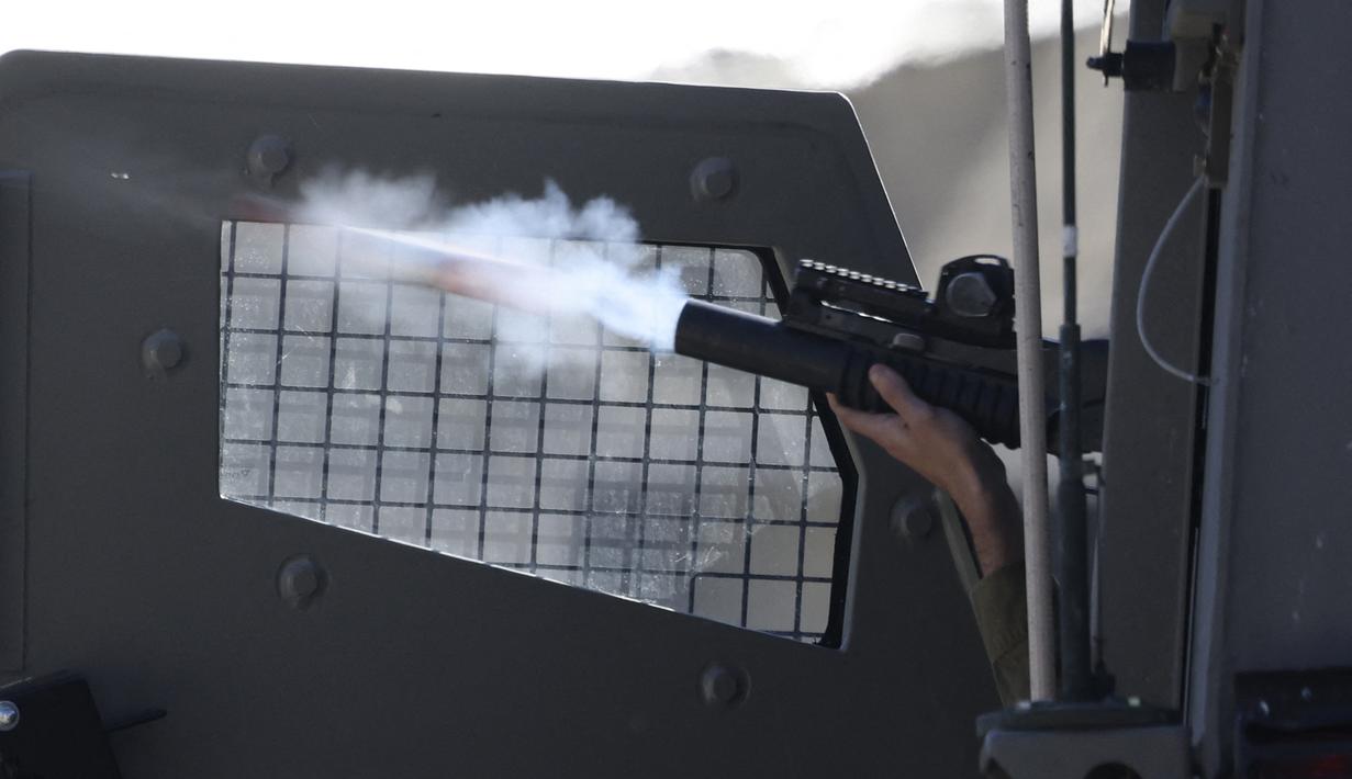 Seorang tentara Israel menembakkan proyektil selama bentrokan di kota Nablus di Tepi Barat yang diduduki pada 3 April 2023, menyusul serangan oleh pasukan Israel. (AFP/Jaafar Ashtiyeh)